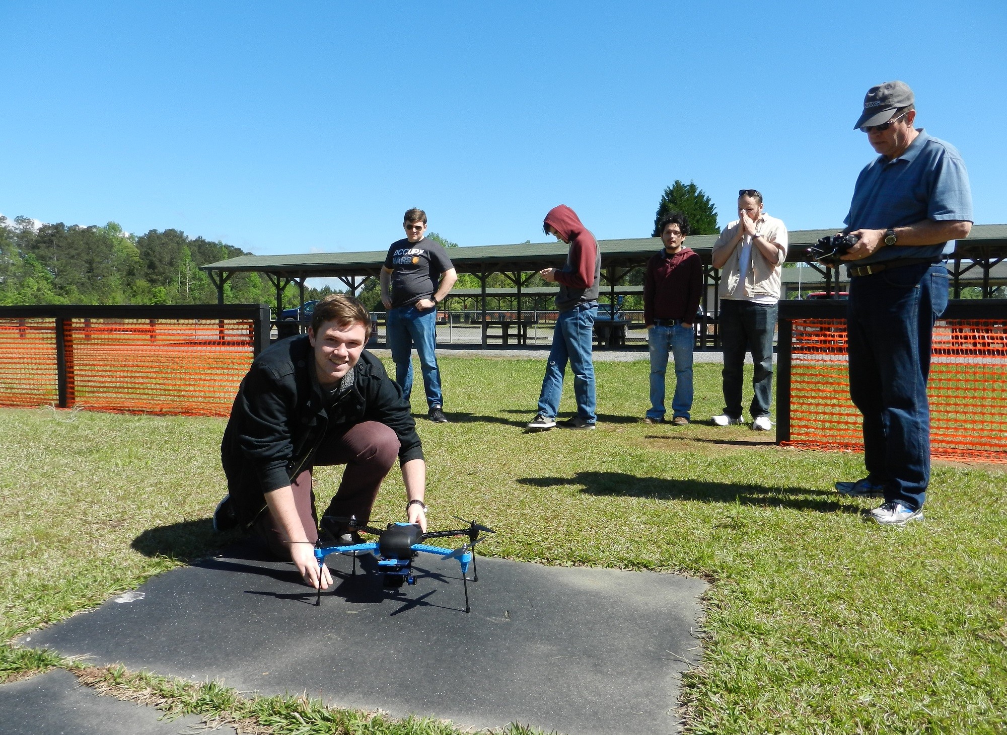 MAPSAN teammate smiling next to the quadcopter