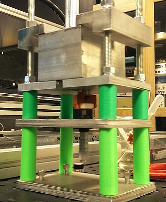 A block of aluminum held in a custom experimental apparatus